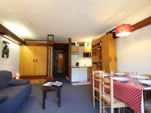 ein Wohnzimmer mit einem Tisch und einer Küche in der Unterkunft Appartement Saint-Chaffrey , 1 pièce, 5 personnes - FR-1-330E-39 in Saint-Chaffrey