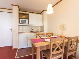 a kitchen and dining room with a wooden table and chairs at Appartement cosy 2 pièces avec parking, proche pistes - La Salle-les-Alpes - FR-1-330F-46 in Serre Chevalier