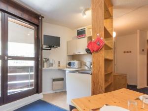 a kitchen with a refrigerator and a table and a window at Appartement Saint-Chaffrey , 1 pièce, 4 personnes - FR-1-330E-46 in Saint-Chaffrey