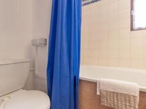 a bathroom with a toilet and a blue shower curtain at Appartement Saint-Chaffrey , 1 pièce, 4 personnes - FR-1-330E-46 in Saint-Chaffrey