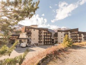 ein Gebäude mit auf einem Parkplatz geparkten Autos in der Unterkunft Charmant studio 4 pers à Serre-Chevalier avec balcon, TV, lave-vaisselle - Animaux non admis - FR-1-330E-43 in Serre Chevalier