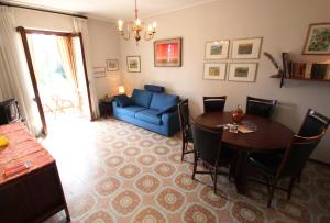 salon ze stołem i niebieską kanapą w obiekcie Lake view Silvano Apartment w mieście Baveno