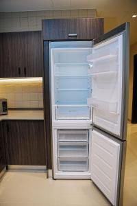 an empty refrigerator with its door open in a kitchen at Abdali Views Apartments in Amman