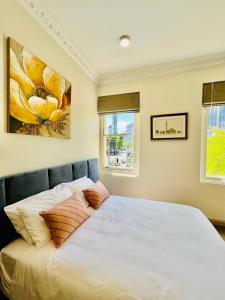 a bedroom with a large white bed with two pillows at Clarendon Hotel in Melbourne