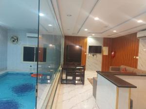 Habitación de hotel con piscina y baño en شاليهات سويت هوم الدرب الكدره, en Ad Darb