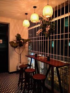 comedor con mesa, sillas y luces en MICHELIA APARTMENT, en Hanói