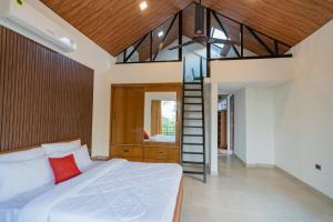 德拉敦SaffronStays Polaris, Dehradun - pet-friendly Swedish home amidst nature的一间带大床和楼梯的卧室