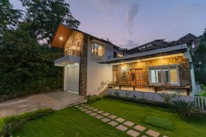 德拉敦SaffronStays Polaris, Dehradun - pet-friendly Swedish home amidst nature的前面有草坪的房子