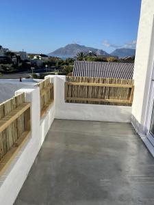 a patio with wooden benches on a building at Rest@Kommetjie in Cape Town +30 photos