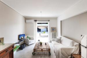 ein Wohnzimmer mit einem weißen Sofa und einem Tisch in der Unterkunft Central Halandri apartment near all hospitals in Athen