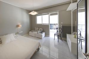 a bedroom with a bed and a couch and a table at Central Halandri apartment near all hospitals in Athens