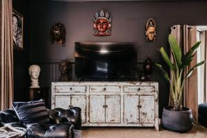 a living room with a tv on top of a dresser at Istana Lodge - Daylesford Region in Musk Vale
