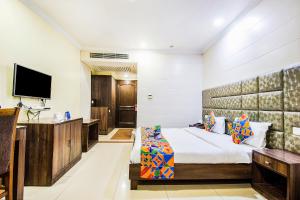 a hotel room with a bed and a flat screen tv at FabHotel Aaykay Model Town in Amritsar