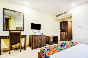 a hotel room with a bed and a tv at FabHotel Aaykay Model Town in Amritsar