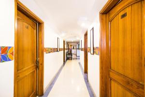 a hallway with wooden doors and white walls at FabHotel Aaykay Model Town in Amritsar