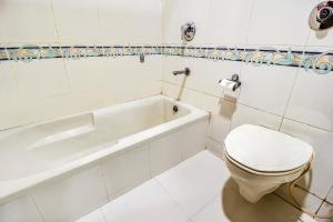 a white bathroom with a toilet and a bath tub at FabHotel Aaykay Model Town in Amritsar