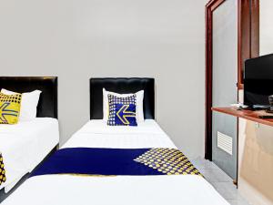 Un pat sau paturi într-o cameră la SPOT ON 91932 Guest House Mustika Syariah
