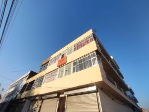 钱德加尔Hotel Yolo- Chandigarh的一座高大的黄色建筑,有很多窗户