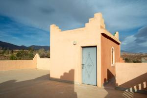 ein Gebäude mit einer blauen Tür auf der Seite in der Unterkunft Afoulki Ecotourism Guest House in Telouet