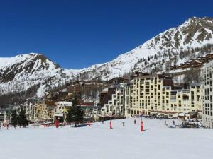 un grand bâtiment dans la neige devant une montagne dans l'établissement Studio Isola 2000, 1 pièce, 4 personnes - FR-1-292-108, à Isola 2000