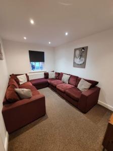 a living room with a large couch and a television at 3 Laurel Court in Ulverston