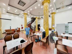 two men standing in the lobby of a hotel at Khách Sạn Cao Sơn Cẩm Phả in Cẩm Phả