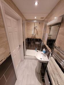 uma casa de banho com um chuveiro, um lavatório e uma banheira em 3 Laurel Court em Ulverston