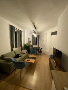 a living room with a green couch and a tv at Appartement deux chambres - Garibaldi in Lyon