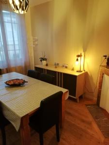 a dining room with a table and chairs and a table and a desk at Jolie maison à 200 m des plages du débarquement in Saint-Aubin-sur-Mer