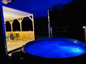 a blue hot tub in a backyard at night at Czerwony Domek in Sasino