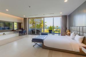 a bedroom with a large bed and a view of the ocean at The Ocean Villa Resort Beachfront By Abogo in Da Nang
