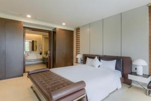 a bedroom with a large white bed and a bathroom at The Ocean Villa Resort Beachfront By Abogo in Da Nang