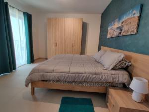 een slaapkamer met een groot bed met een houten hoofdeinde bij Sahariana Sand in Marsaskala