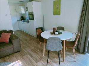 een woonkamer met een tafel en stoelen en een keuken bij 4p chalet TOLVE met 4 fietsen vlakbij natuurgebieden Drents Friese Wold, Fochteloërveen en gevangenisdorp Veenhuizen in Oosterwolde