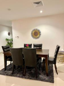 a dining room with a wooden table and chairs at Iconic 4-bedroom villa with pool in Fujairah Palm in Fujairah