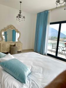 Iconic 4-bedroom villa with pool in Fujairah Palm في الفجيرة: غرفة نوم مع سرير أبيض كبير مع نافذة
