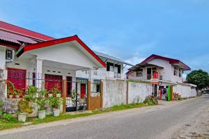 a row of houses on the side of a street at SPOT ON 91950 Guest House TekNong Syariah in Bangkinang