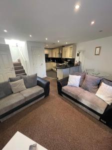 sala de estar con 2 sofás y cocina en 4 Laurel Court, en Ulverston
