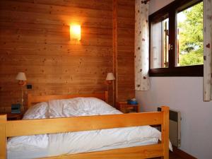 a bedroom with a bed with a wooden wall at Appartement Le Grand-Bornand, 3 pièces, 6 personnes - FR-1-241-171 in Le Grand-Bornand