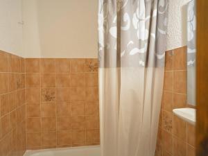 a shower with a white shower curtain in a bathroom at Studio Le Grand-Bornand, 1 pièce, 4 personnes - FR-1-241-173 in Le Grand-Bornand