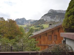 a wooden house with mountains in the background at Studio Le Grand-Bornand, 1 pièce, 5 personnes - FR-1-241-173 in Le Grand-Bornand