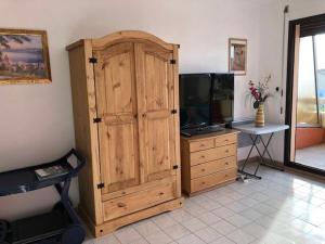 een grote houten kast in een kamer met een televisie bij Studio Le Lavandou, 1 pièce, 2 personnes - FR-1-308-73 in Le Lavandou