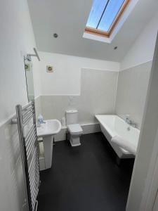 baño con lavabo y aseo y ventana en 4 Laurel Court, en Ulverston