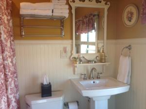 y baño con lavabo, espejo y aseo. en The Destination B&B llc, en Salem