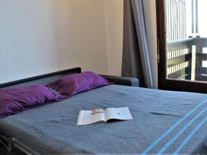 リスルにあるAppartement Risoul, 1 pièce, 4 personnes - FR-1-330-288の窓付きのベッドの上に座る本