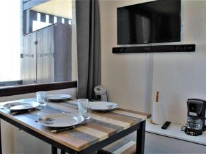 リスルにあるAppartement Risoul, 1 pièce, 4 personnes - FR-1-330-288の木製テーブル(皿付)、テレビ付