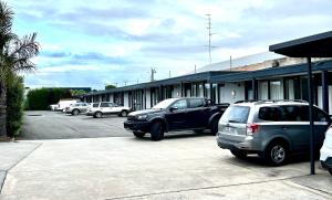 two cars parked in a parking lot next to a building at Colac Central Motel in Colac