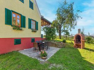 a house with a table and chairs in the yard at Holiday home in Gersdorf near a swimming lake in Gersdorf an der Feistritz