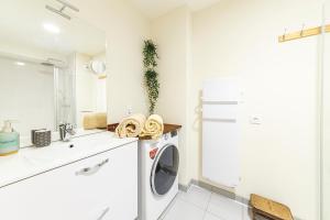 uma casa de banho branca com uma máquina de lavar roupa em Le B3 de Claire - Résidence La Montille em Le Mont-Dore