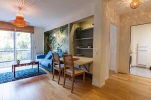 uma sala de estar com uma mesa e um sofá azul em Le B3 de Claire - Résidence La Montille em Le Mont-Dore